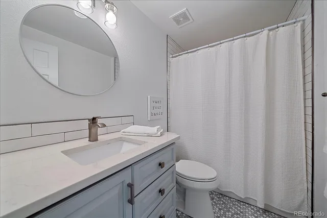 a bathroom with a sink a toilet and a mirror