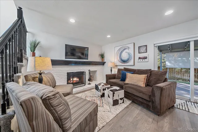 a living room with furniture a large window and a fireplace