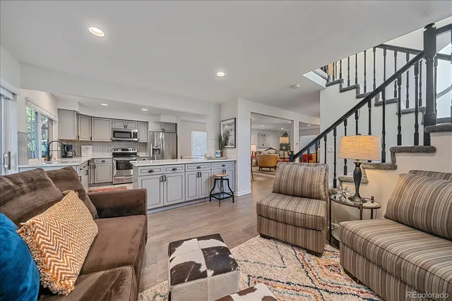 a living room with furniture and a view of kitchen