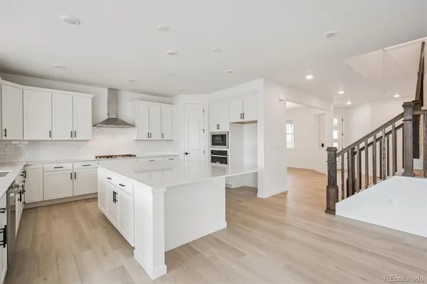 a kitchen with a white stove top oven and white cabinets