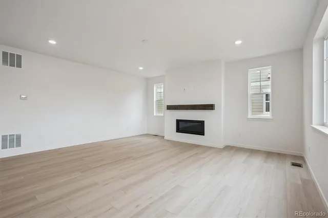 a view of empty room with wooden floor and fireplace