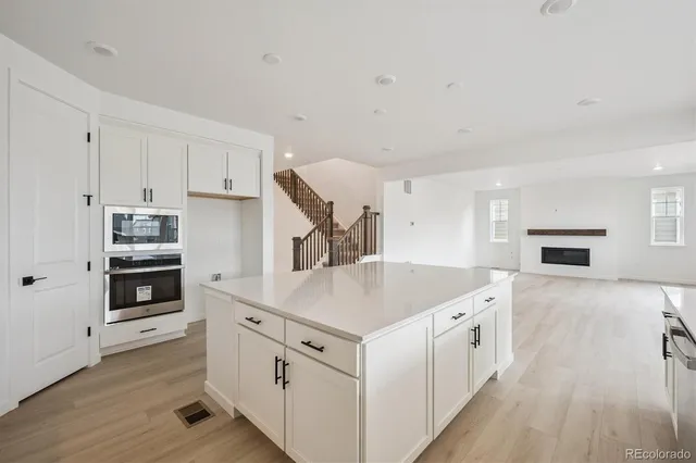 a kitchen with cabinets and wooden floor