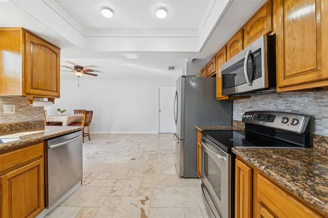 a kitchen with stainless steel appliances granite countertop a sink stove and cabinets