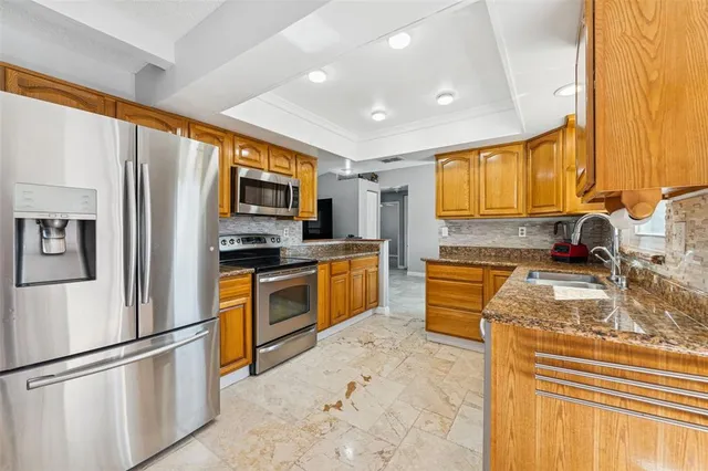 a kitchen with stainless steel appliances granite countertop a refrigerator stove microwave and sink