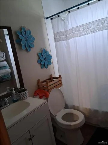 a bathroom with a toilet and a shower curtain