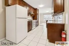 a kitchen with kitchen island granite countertop a refrigerator a sink and dishwasher