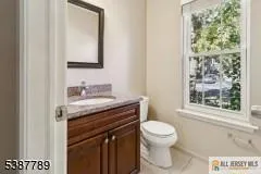 a bathroom with a granite countertop sink a toilet and a mirror
