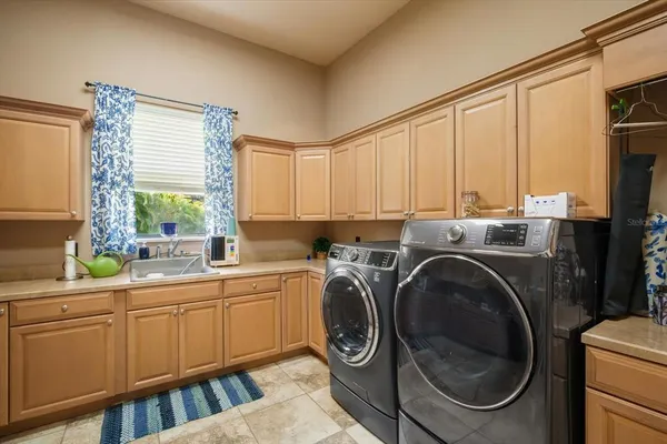 a bedroom with a bed a chandelier and a large window
