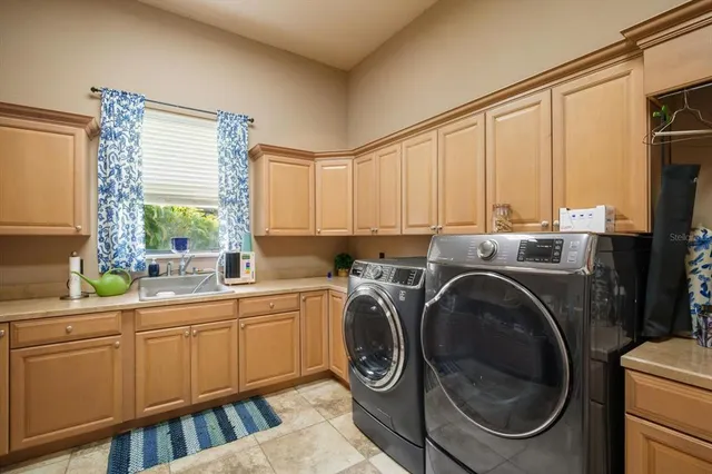 a bedroom with a bed a chandelier and a large window