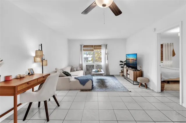 a living room with furniture a flat screen tv and a window