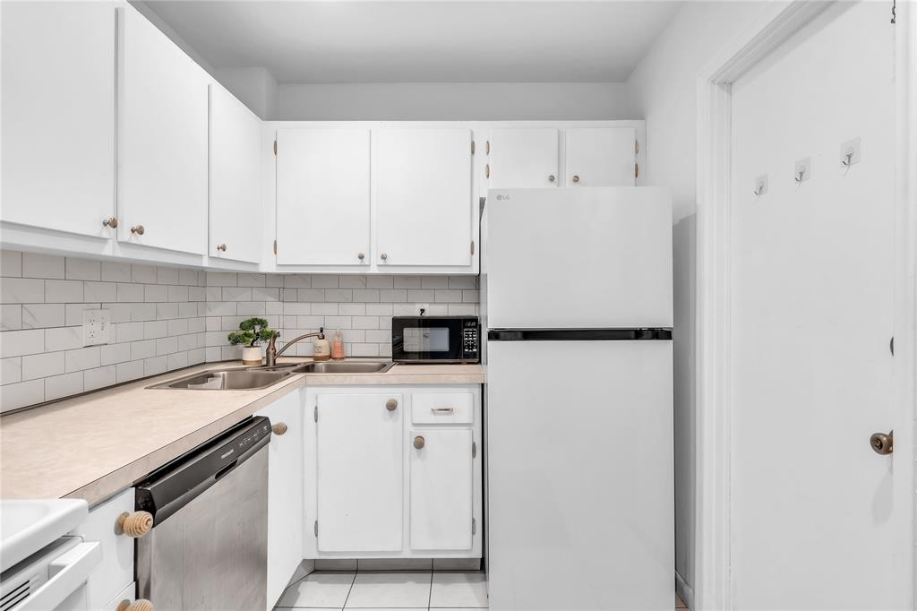 1950 North Andrews Avenue, Unit 210D Wilton Manors, FL 33305 - Photo 23 of 52 a kitchen with stainless steel appliances granite countertop white refrigerator stove and white cabinets
