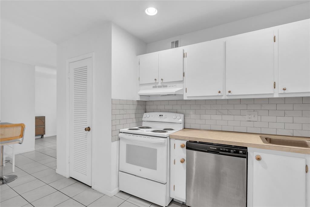 1950 North Andrews Avenue, Unit 210D Wilton Manors, FL 33305 - Photo 26 of 52 a kitchen with white cabinets and white appliances