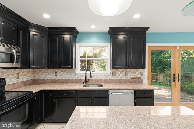 a kitchen with stainless steel appliances granite countertop a sink and a stove top oven