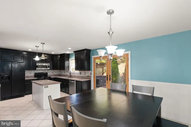 a kitchen with stainless steel appliances granite countertop a sink a refrigerator and a stove