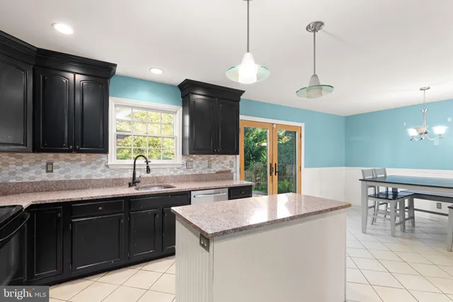 a kitchen with a sink a center island and cabinets