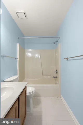 a bathroom with a granite countertop sink a toilet and shower