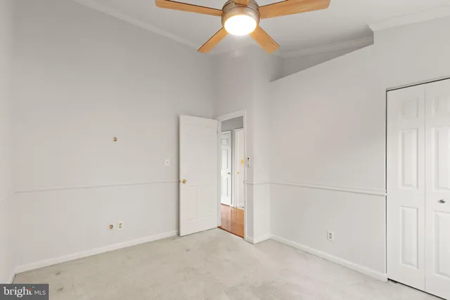an empty room with a ceiling fan and a window