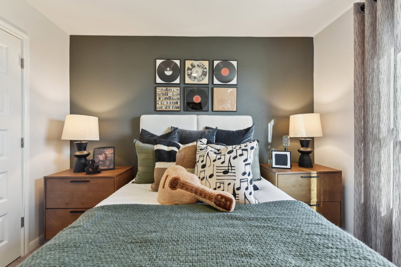 A comfortable bedroom space featuring carpeted flooring and a tall window.