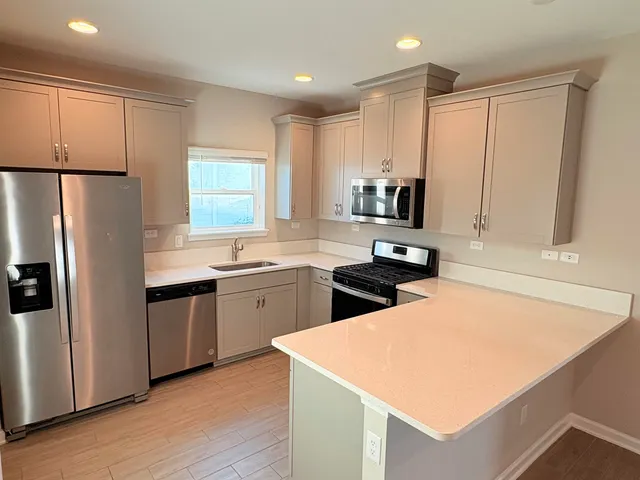 a kitchen with stainless steel appliances a refrigerator sink and microwave