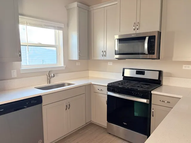 a kitchen with white cabinets stainless steel appliances and sink