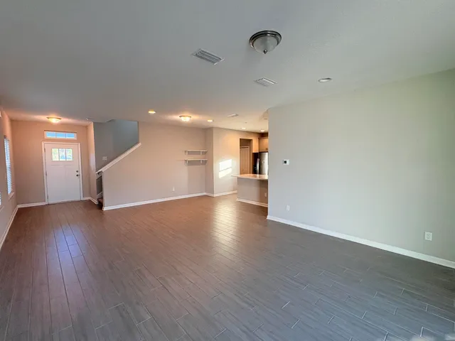 a view of empty room with wooden floor