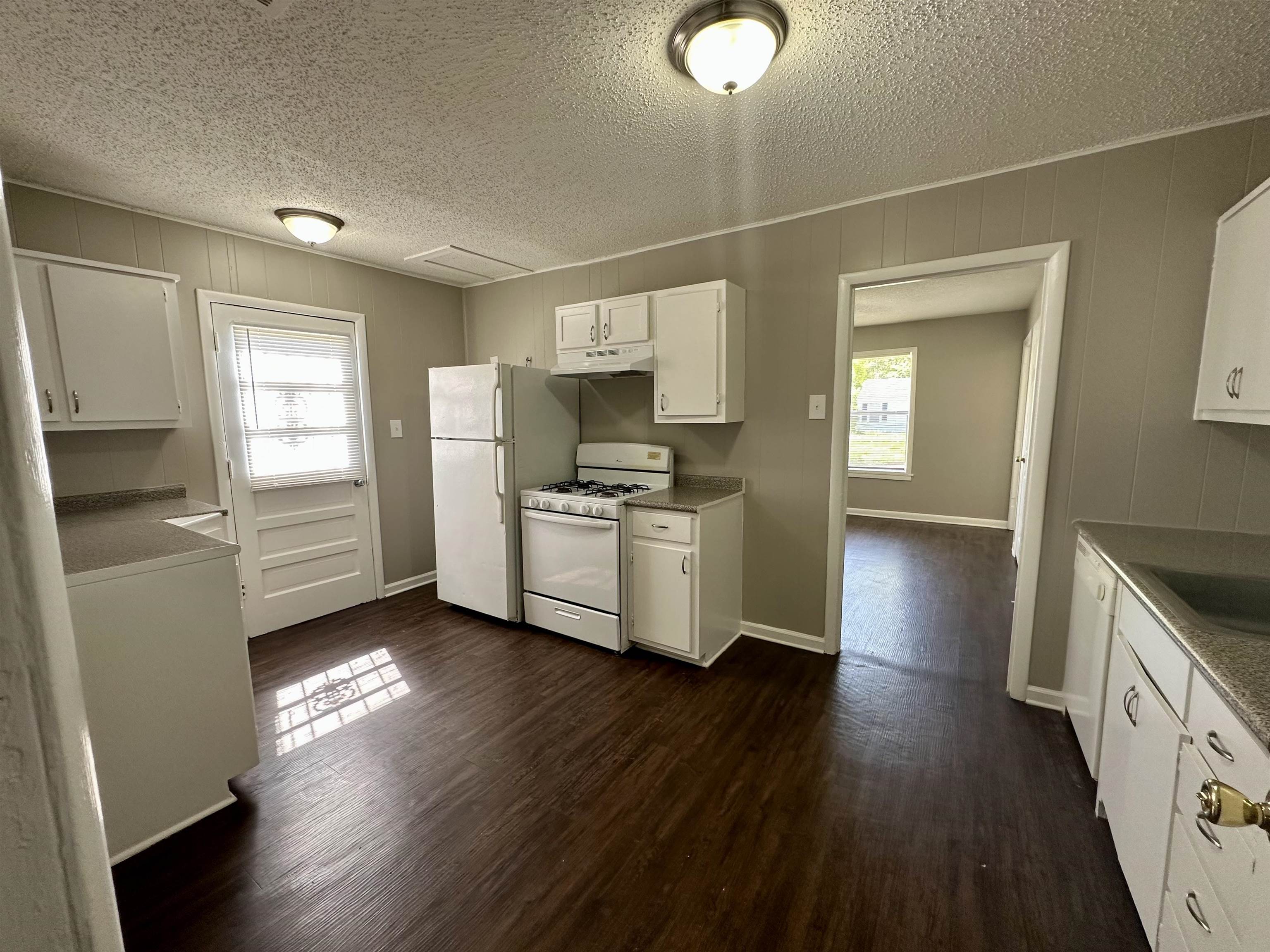 296 Glencoe Road Memphis, TN 38109 - Photo 12 of 18 a kitchen with granite countertop a refrigerator and a stove top oven
