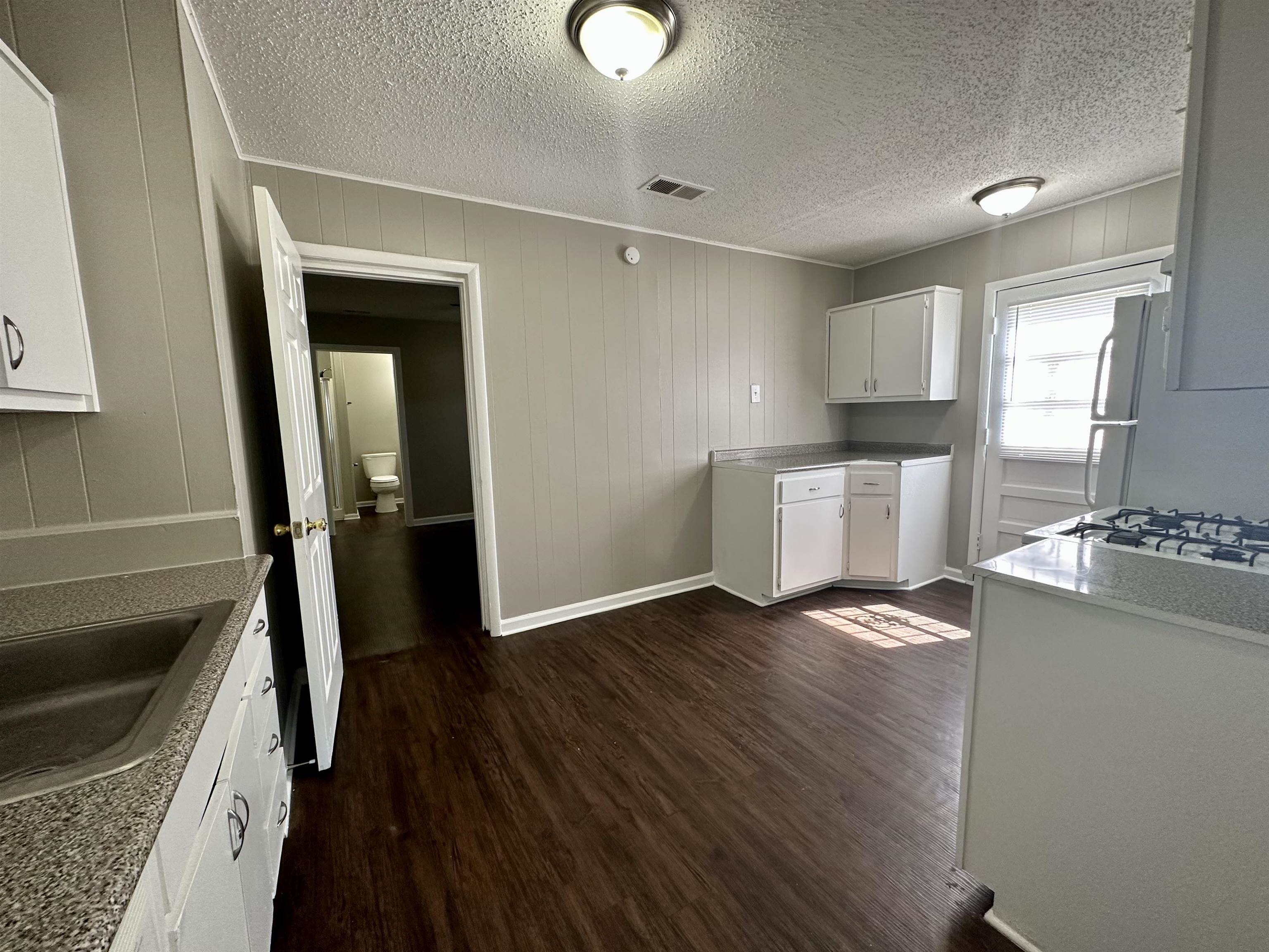 296 Glencoe Road Memphis, TN 38109 - Photo 14 of 18 a kitchen with granite countertop a sink stove and refrigerator