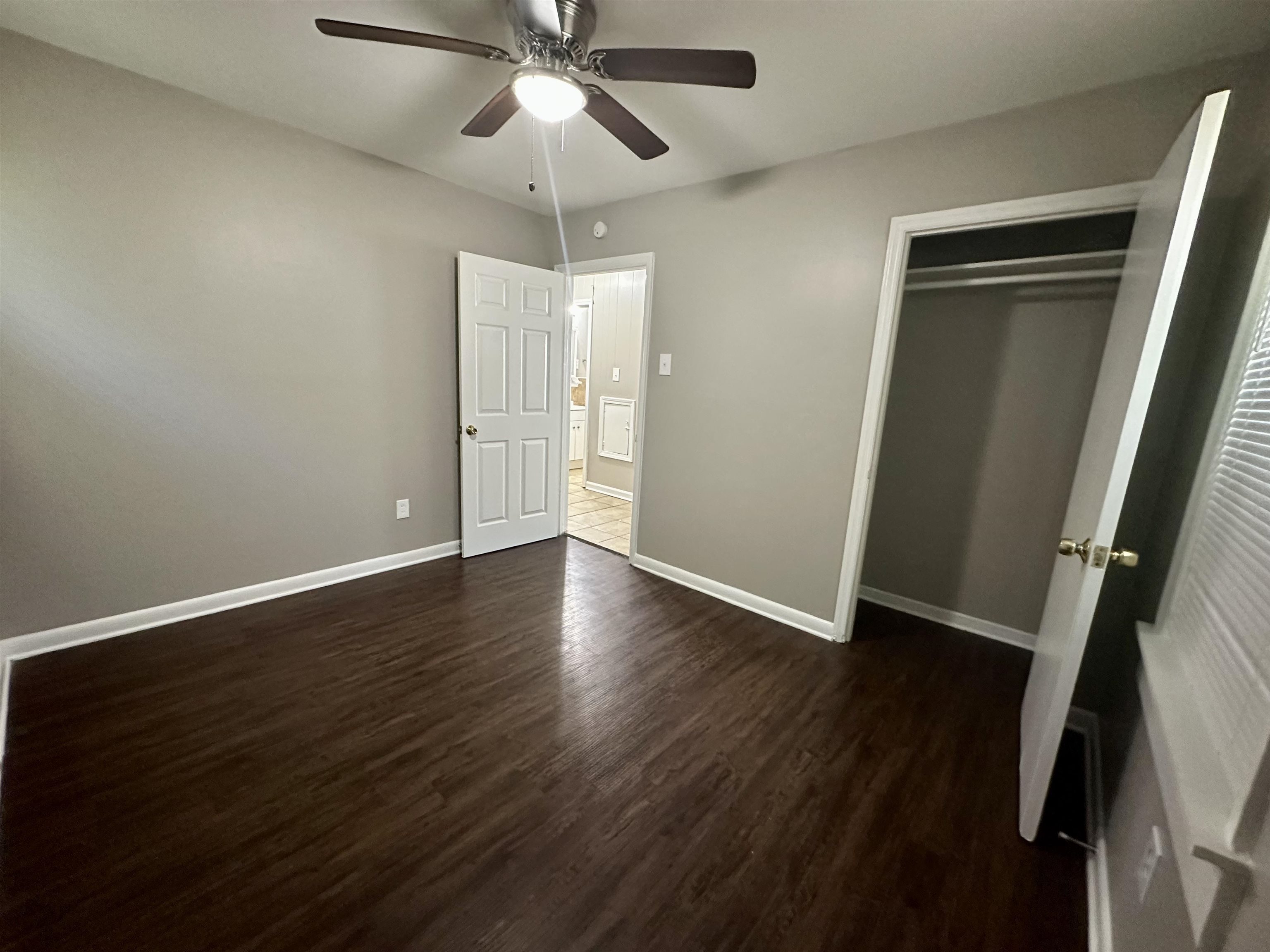 296 Glencoe Road Memphis, TN 38109 - Photo 4 of 18 an empty room with wooden floor fan and window