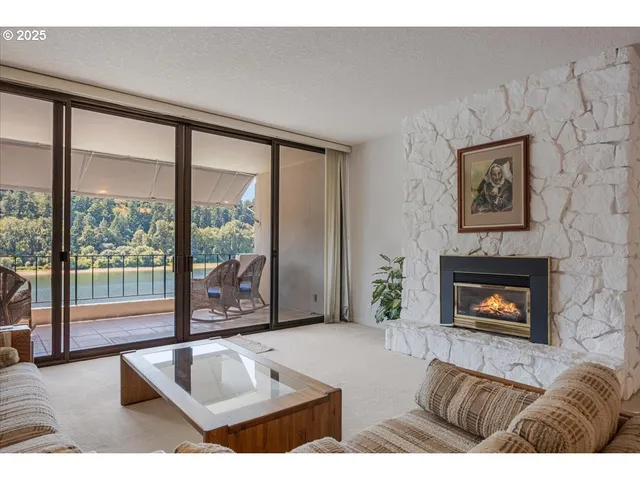 a living room with furniture large window and fireplace