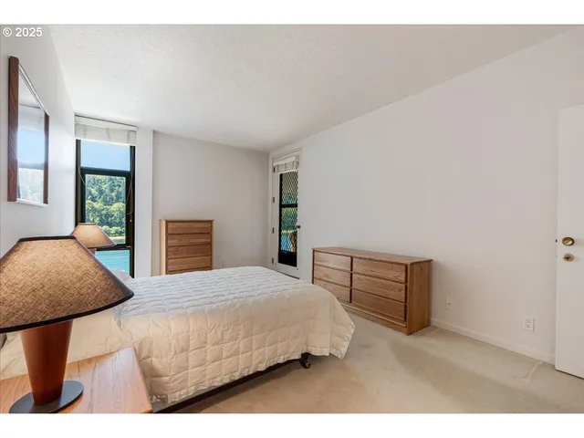 a bedroom with a bed a table and dresser