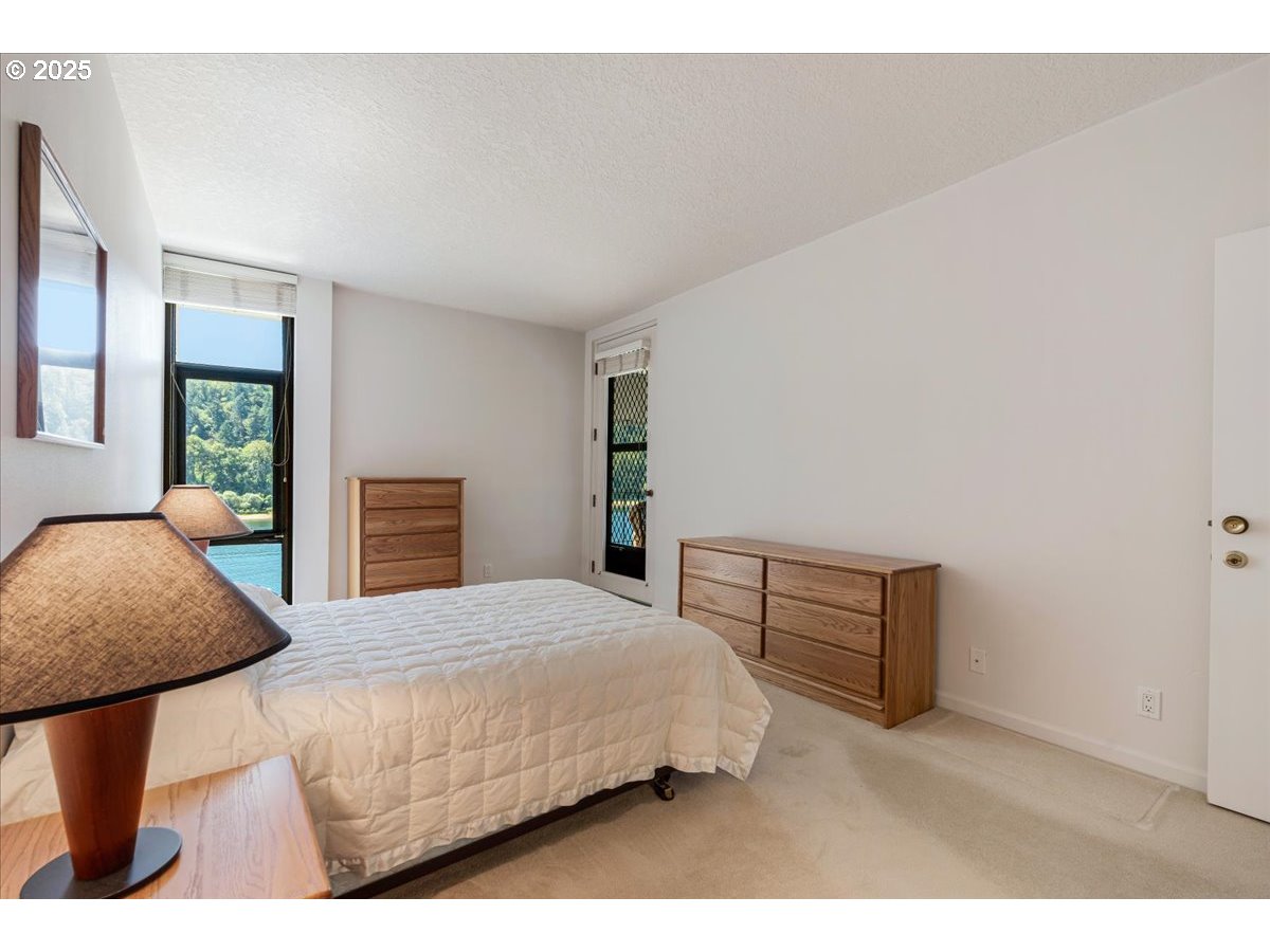 790 Southeast Webber Street, Unit 305 Portland, OR 97202 - Photo 19 of 30 a bedroom with a bed a table and dresser