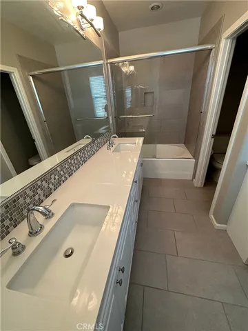 a bathroom with a tub a sink and a mirror
