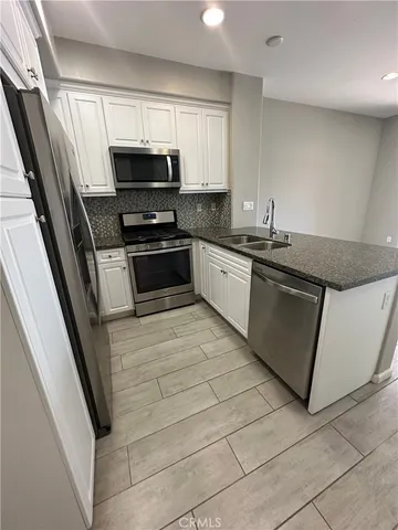 a kitchen with granite countertop a sink and a stove top oven