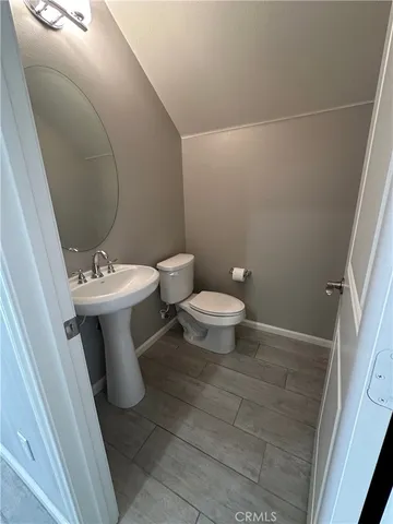 a white toilet sitting next to a white sink and vanity