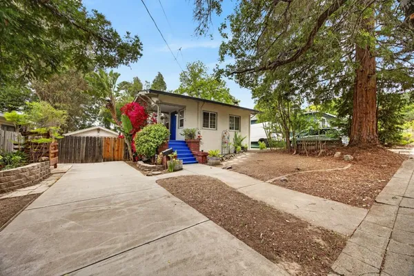 a front view of a house with a yard and trees