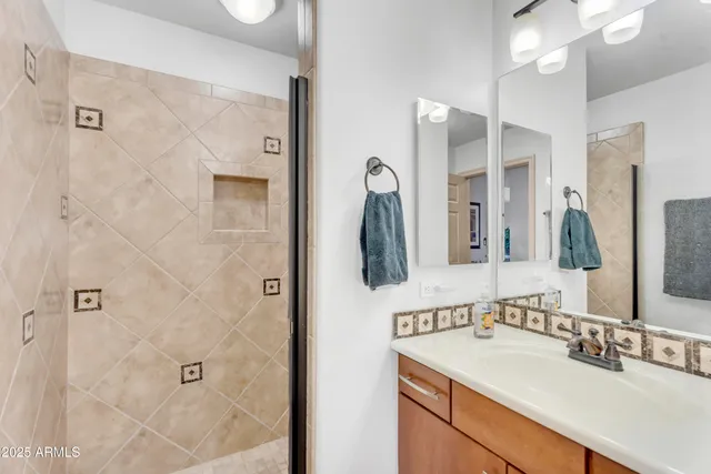 a bathroom with a sink vanity granite shower and a mirror