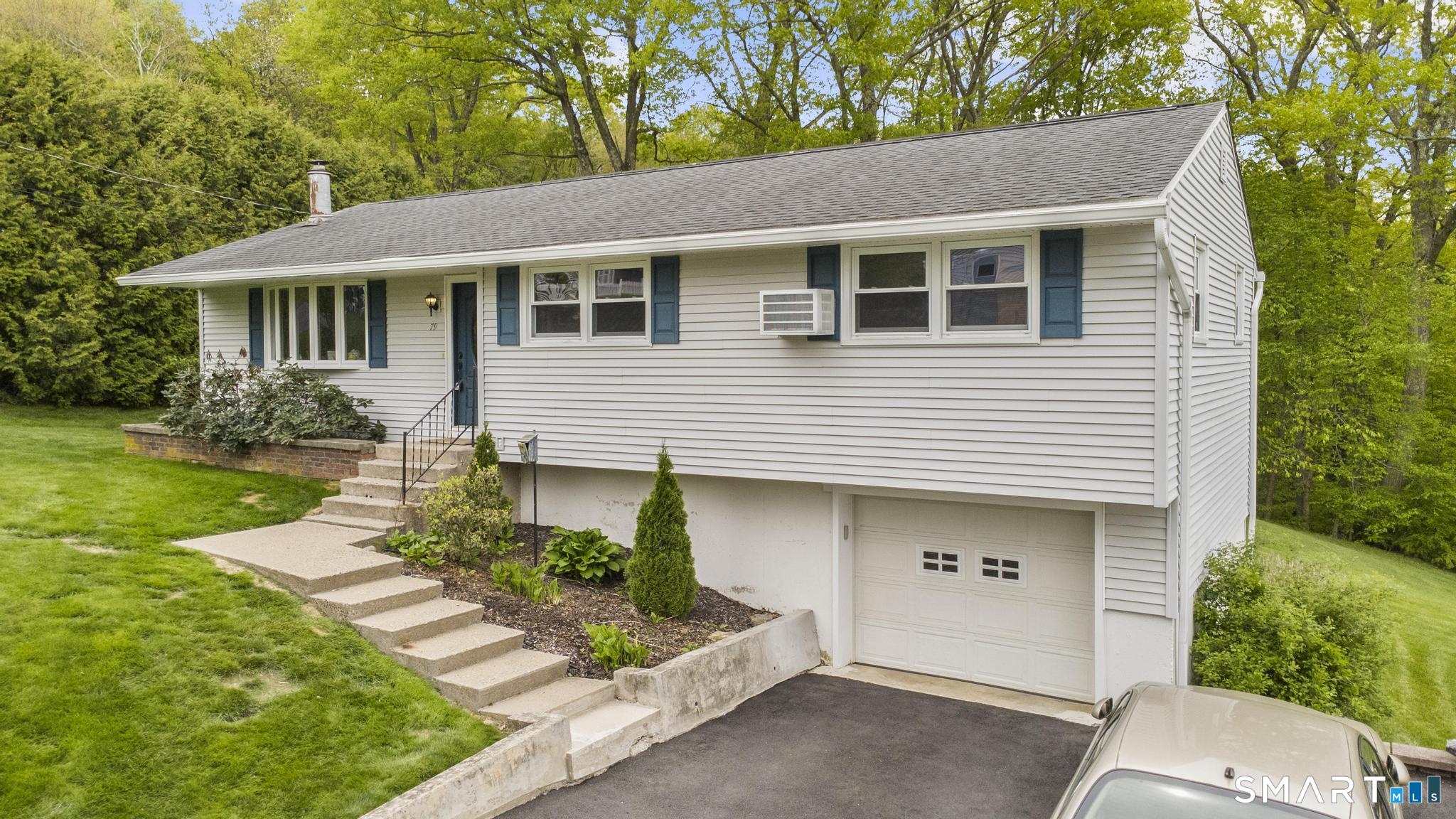 79 Forest View Drive Wolcott, CT 06716 - Photo 3 of 28 a front view of a house with a yard and garage