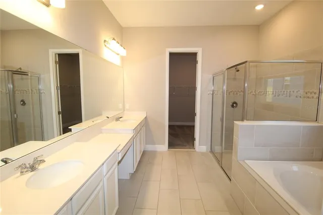 a spacious bathroom with a tub shower and sink
