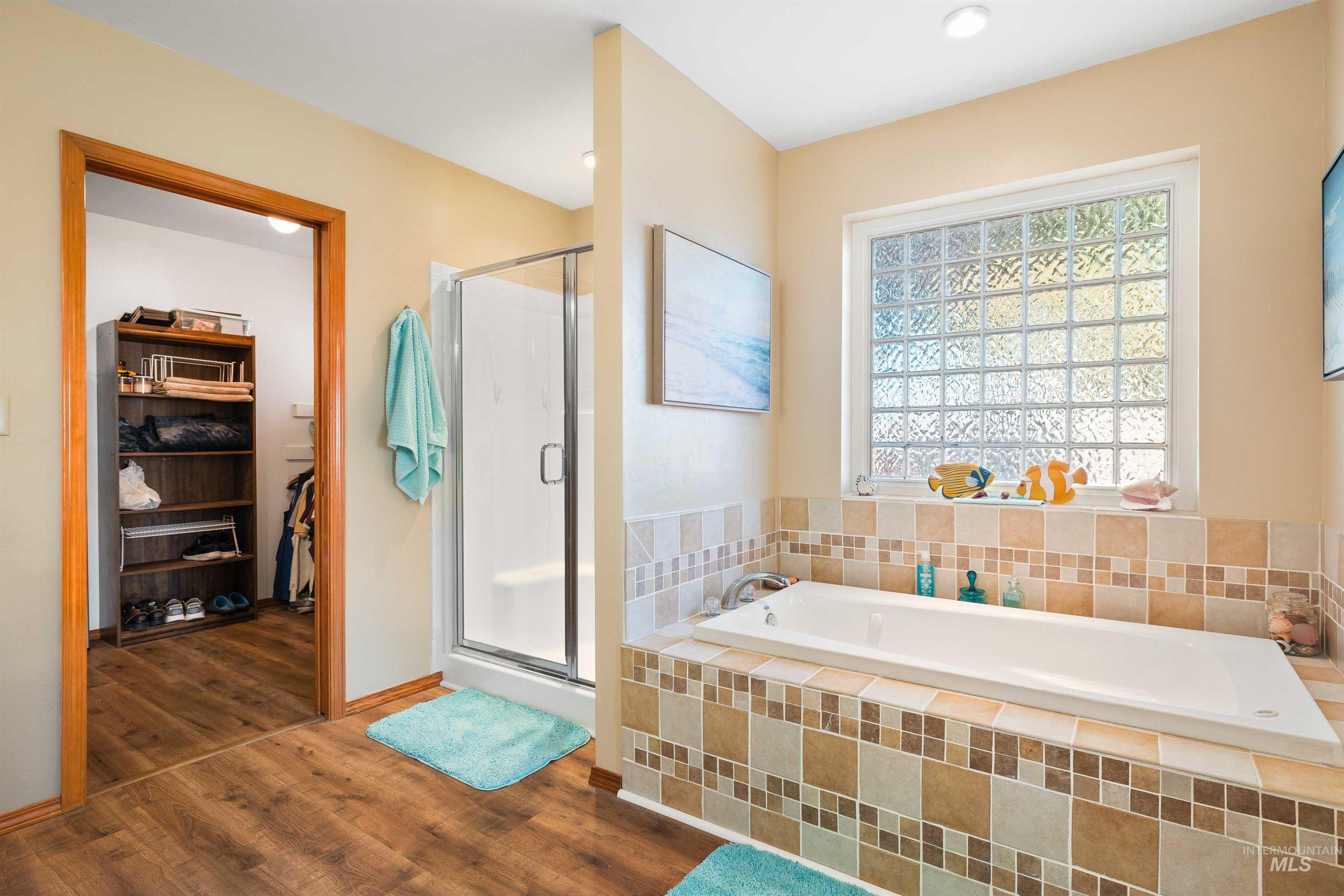 430 Pierce Street Twin Falls, ID 83301 - Photo 14 of 39 Full bath with a stall shower, a bath, a walk in closet, and dark wood finished floors