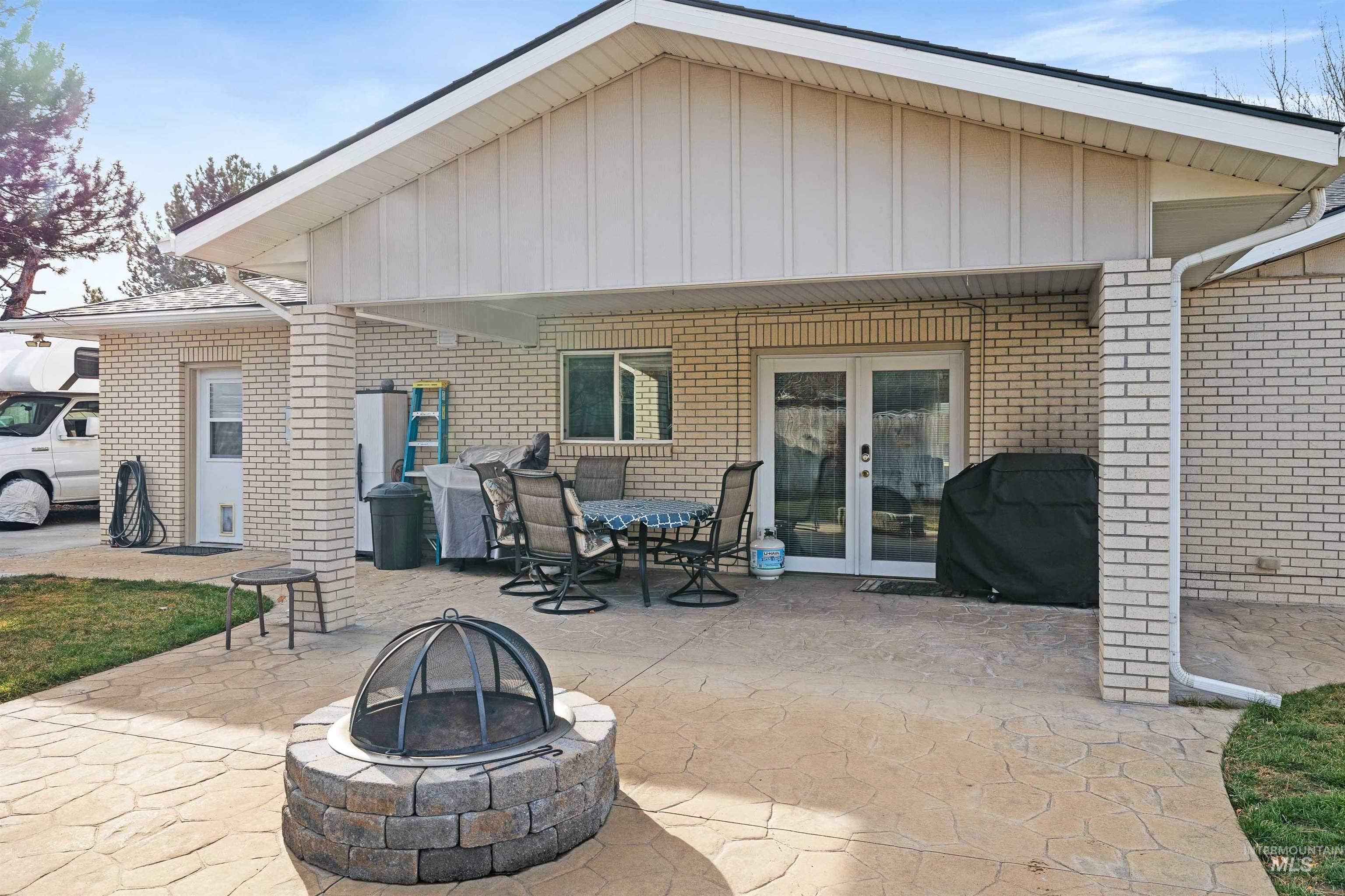 430 Pierce Street Twin Falls, ID 83301 - Photo 26 of 39 Back of house with a patio area, an outdoor fire pit, french doors, brick siding, and board and batten siding