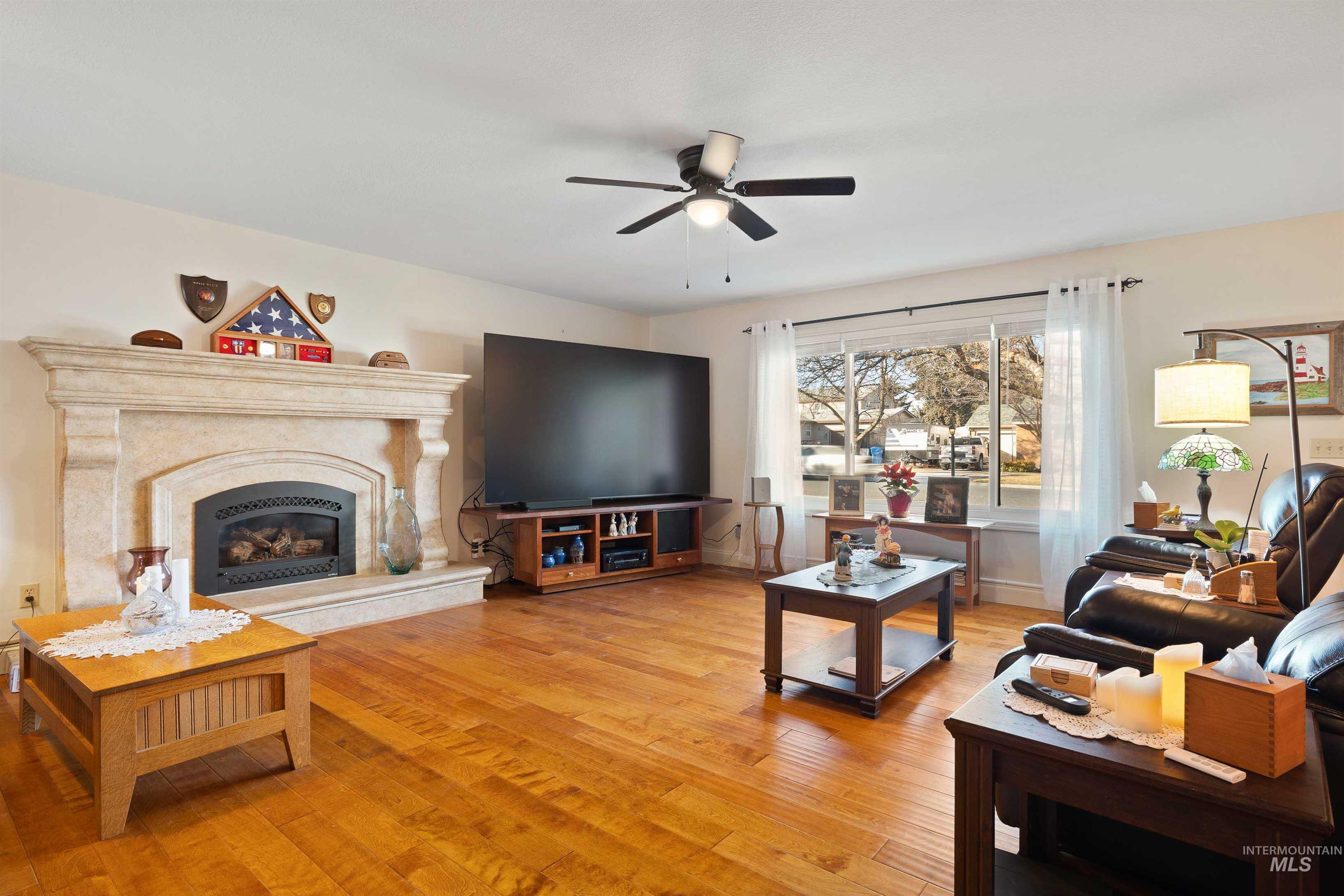 430 Pierce Street Twin Falls, ID 83301 - Photo 5 of 39 Living area featuring light wood finished floors, ceiling fan, and a premium fireplace