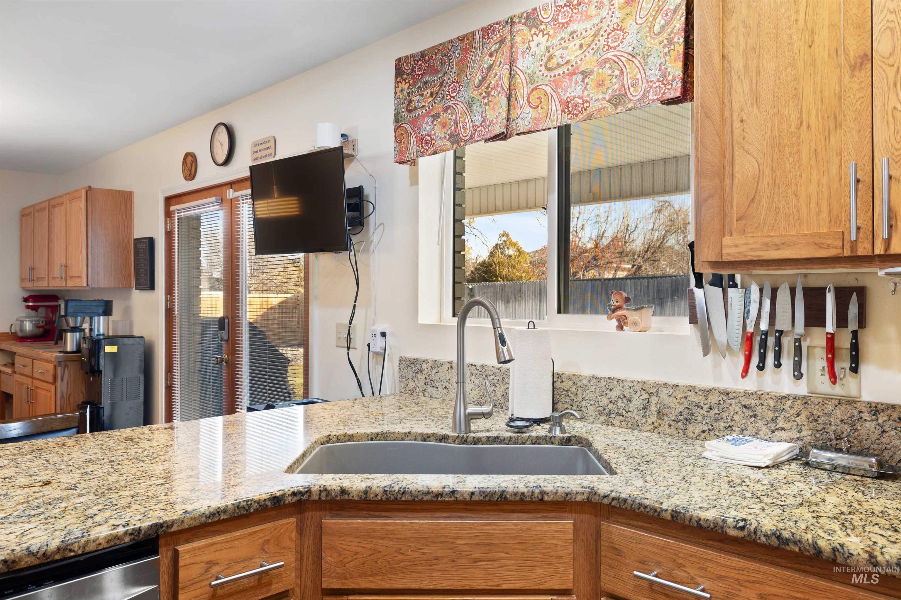 430 Pierce Street Twin Falls, ID 83301 - Photo 9 of 39 Kitchen with light stone counters, wood finish cabinetry, and stainless steel dishwasher
