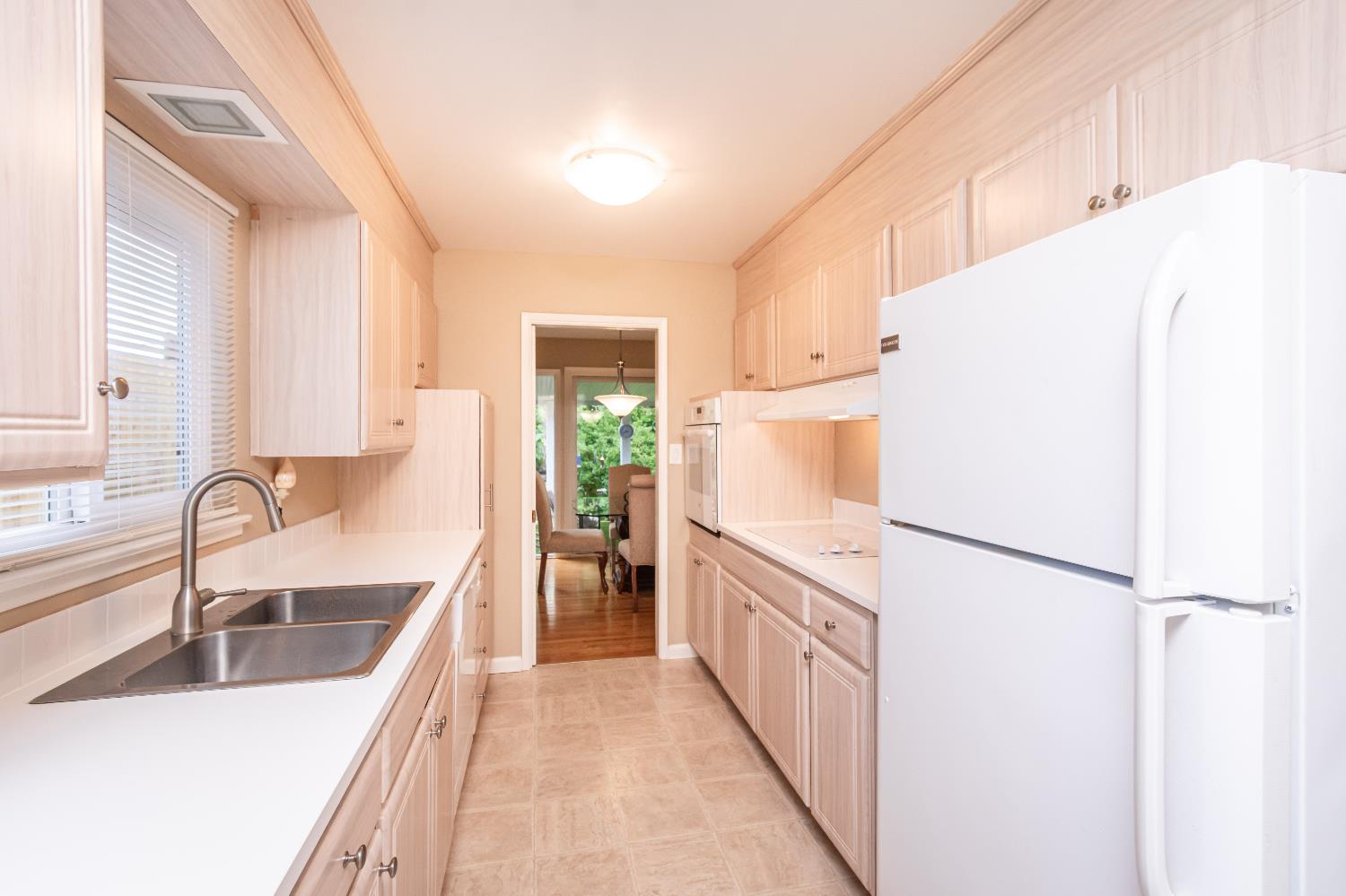 5310 Fort Sutter Way Sacramento, CA 95841 - Photo 23 of 55 a kitchen with a refrigerator a sink and white cabinets