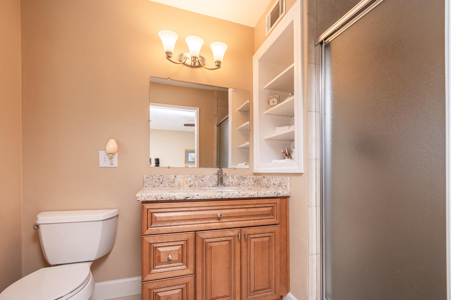 5310 Fort Sutter Way Sacramento, CA 95841 - Photo 32 of 55 a bathroom with a granite countertop toilet sink and mirror