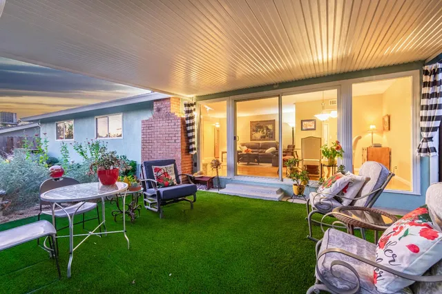 a backyard of a house with dining table and chairs