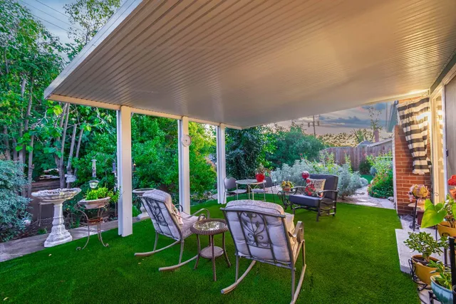 a front view of a house with a yard and potted plants