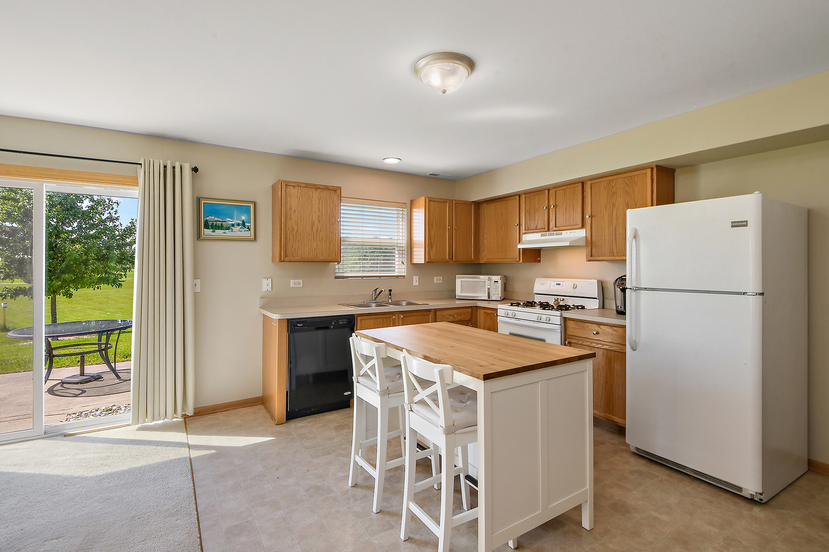 25117 Faraday Road Manhattan, IL 60442 - Photo 8 of 19 a kitchen with a white refrigerator stove a sink dishwasher and a refrigerator with wooden floor