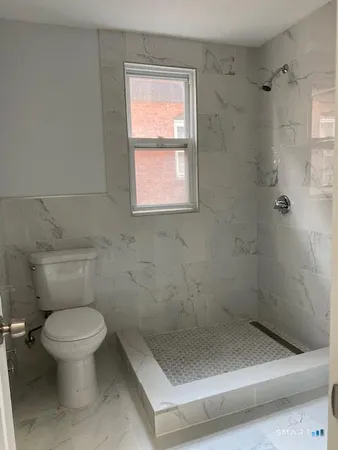 a bathroom with a toilet and a shower