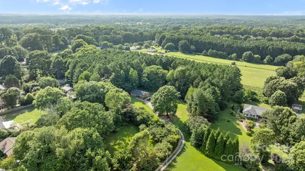 an aerial view of residential houses with outdoor space and trees
