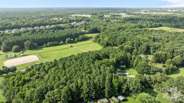 an aerial view of a house with a yard and outdoor seating